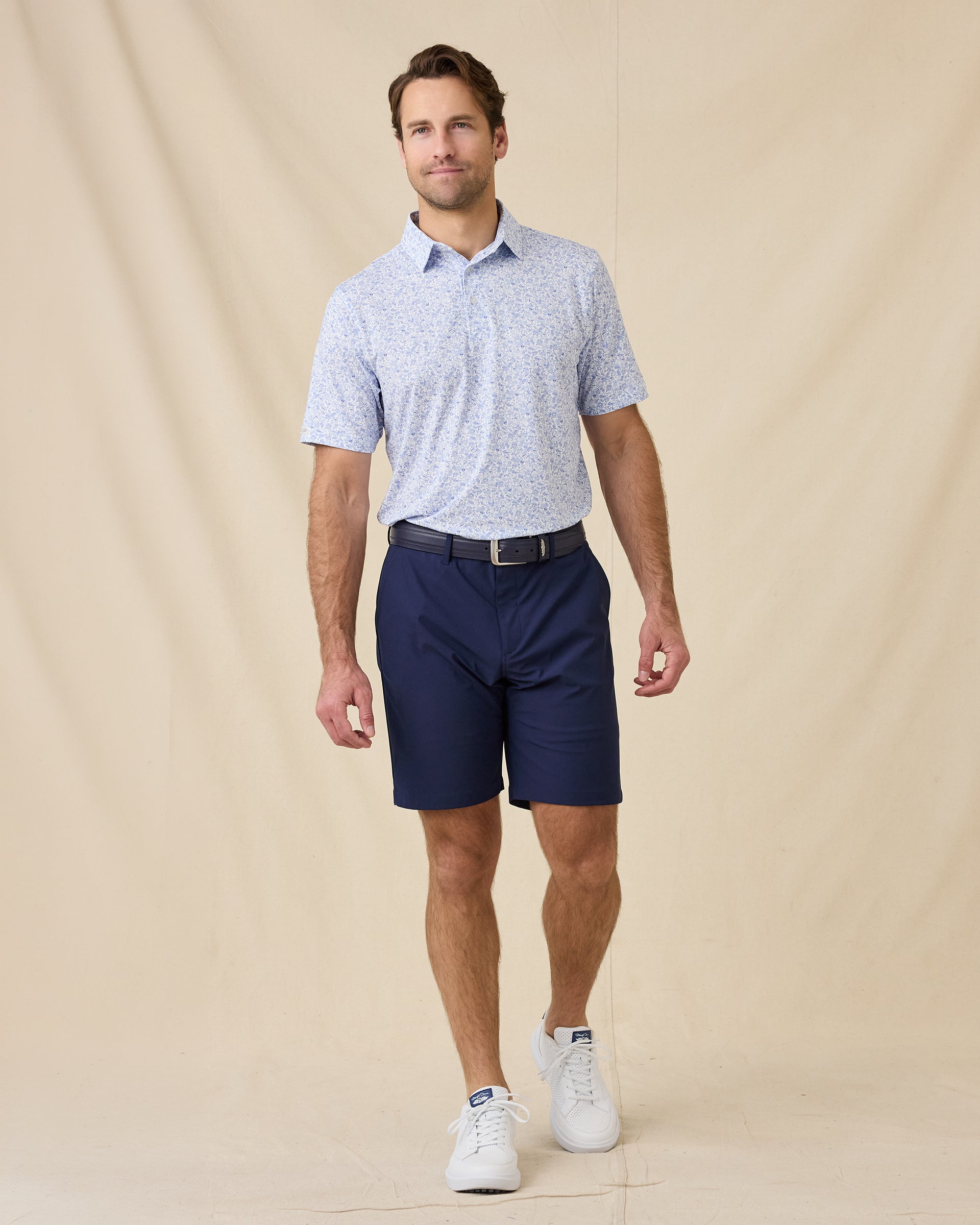Model wearing the Poker Dawgs Polo in Tidal Blue paired with navy golf shorts
