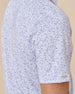 Sleeve detail of the Poker Dawgs Polo in Tidal Blue showing the allover poker-themed dog print and Straight Down logo patch