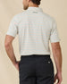Back view of model wearing the Oceano Dunes Striped Polo in Cantaloupe, showing the horizontal stripe pattern and embroidered logo below the collar.