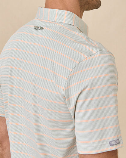Close-up back view of the Oceano Dunes Striped Polo in Cantaloupe showing the striped collar, embroidered logo, and sleeve logo patch.
