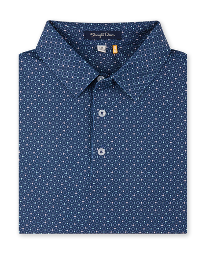 Close-up product view of the Casino Polo in Blue Shade, featuring an allover geometric pattern with small pastel playing card suit motifs, a classic collar, and button placket.