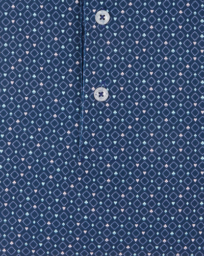 Detail view of the Casino Polo in Blue Shade showing the geometric pattern, small pastel playing card suit motifs, and branded buttons.