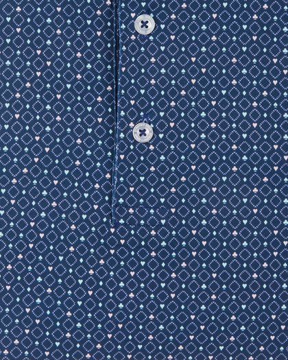 Detail view of the Casino Polo in Blue Shade showing the geometric pattern, small pastel playing card suit motifs, and branded buttons.