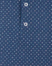 Detail view of the Casino Polo in Blue Shade showing the geometric pattern, small pastel playing card suit motifs, and branded buttons.
