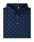 Close-up product view of the Al Fresco Polo in New Indigo, featuring an allover blue and pink floral motif, classic collar, and button placket.