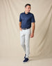 Model wearing the Al Fresco Polo in New Indigo with light gray pants, a navy belt, and navy sneakers.