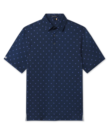 Front product view of the Al Fresco Polo in New Indigo, featuring a navy base with an allover blue and pink floral motif, short sleeves, and button placket.