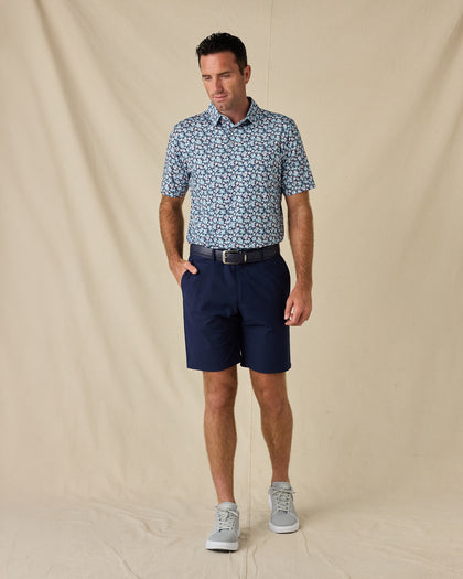 Model wearing the Point Reyes Polo in Mint Tea with navy golf shorts, a coordinating belt, and gray sneakers.