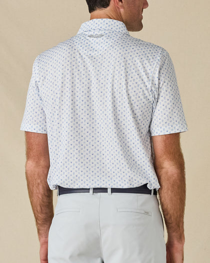 Back view of the Trader Vics Polo in Blue Shade, highlighting the all-over geometric print and embroidered logo below the collar.