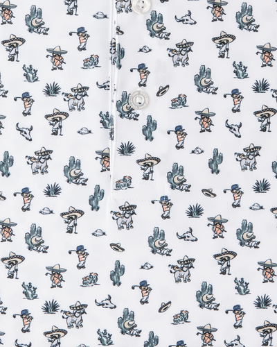 Close-up of the Siesta Polo showing the white fabric, button placket, and colorful Western-inspired print with golfers, cacti, and desert motifs.