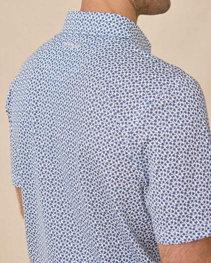 Back shoulder detail of the Date Palm Polo in New Indigo featuring a subtle embroidered Straight Down logo and allover palm tree print