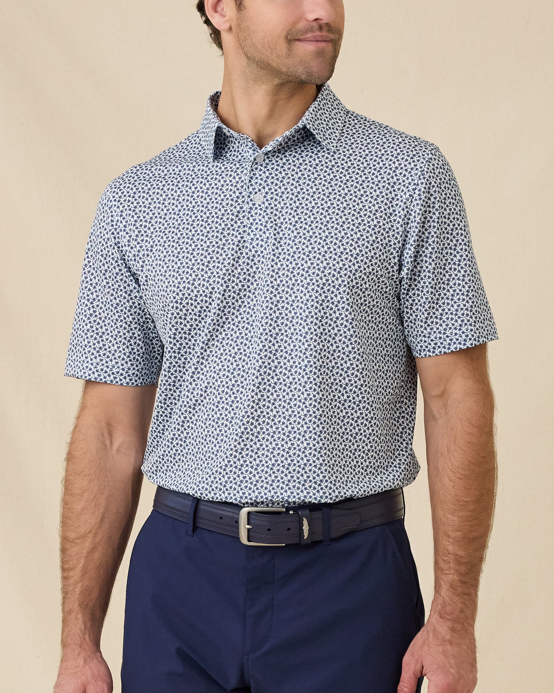 Model wearing the Date Palm Polo in New Indigo featuring a micro palm tree print