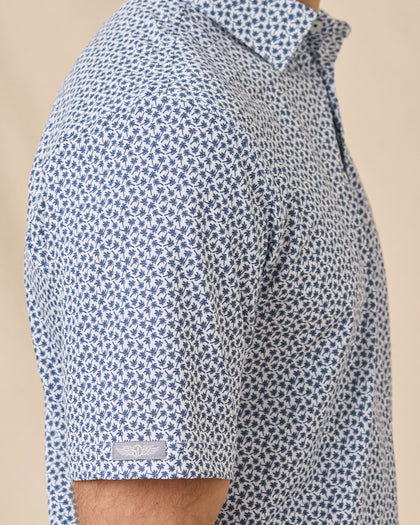 Sleeve detail of the Date Palm Polo in New Indigo highlighting the palm tree print and Straight Down logo tab