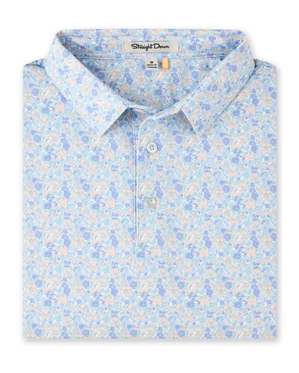 Folded Pasadena Polo in Lake featuring an all-over floral print in soft blue, lavender, aqua, and peach tones.