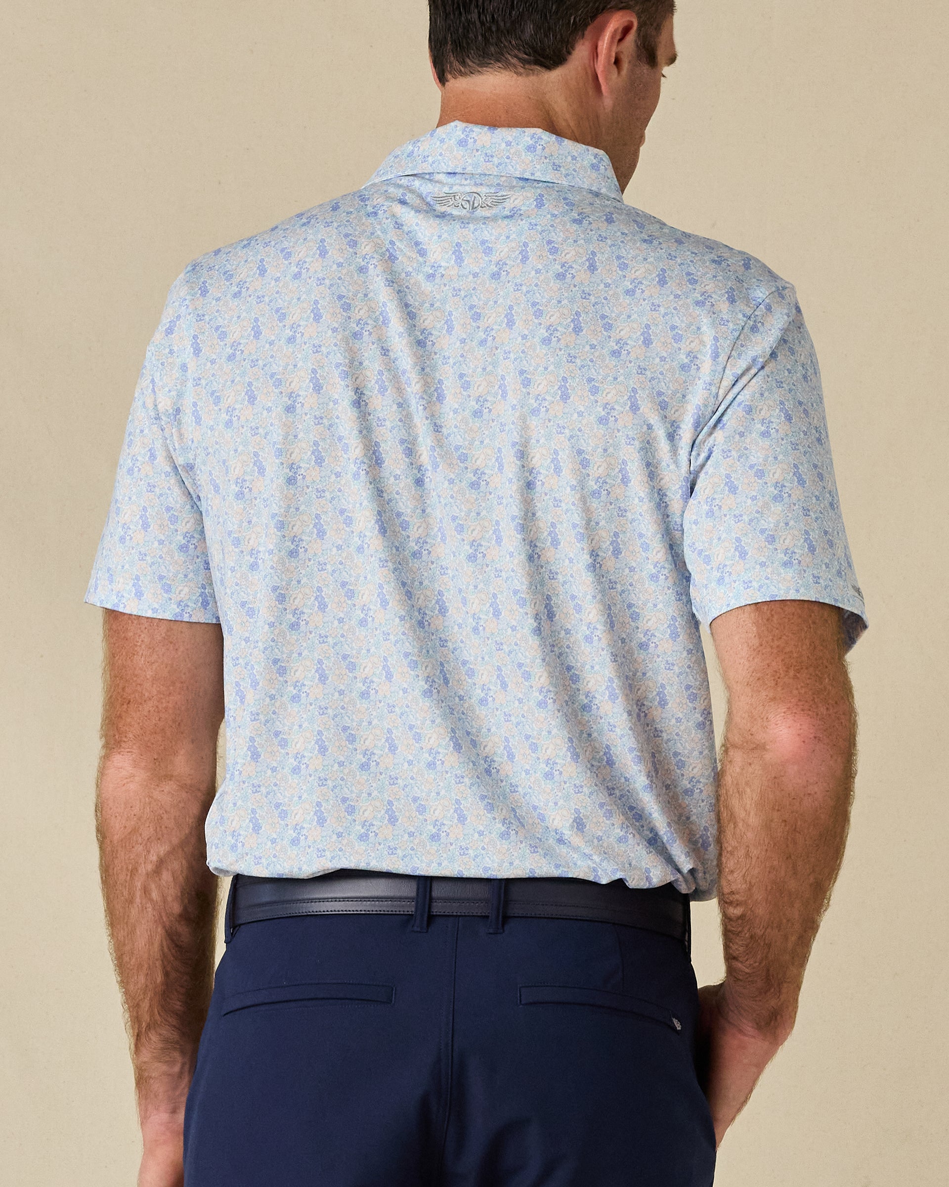 Back view of the Pasadena Polo in Lake, highlighting the floral print and embroidered logo below the collar.