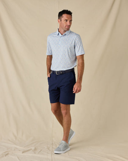 Model wearing the Pasadena Polo in Lake with navy golf shorts, a coordinating belt, and gray sneakers.
