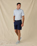 Model wearing the Pasadena Polo in Lake with navy golf shorts, a coordinating belt, and gray sneakers.