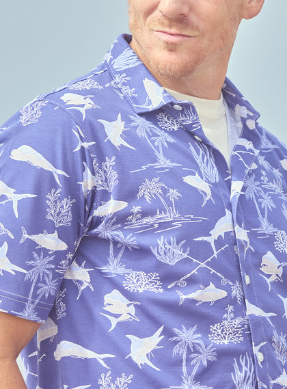 Islamorada Full Button Polo in Skipper, on model close-up front view highlighting the all-over white nautical print of marlin, sailfish, coral, and palm trees on a blue base