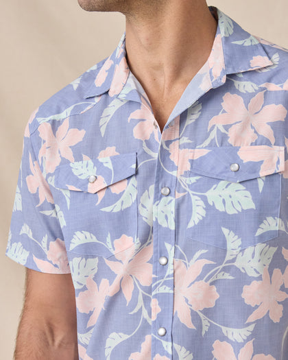 Close-up of the blue floral shirt’s open collar, pearl snap front and dual chest pockets.