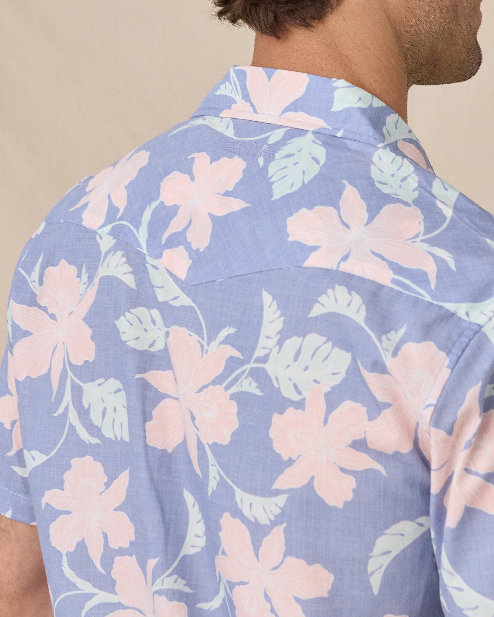 Close-up of the back collar and floral print on the blue short-sleeve shirt.