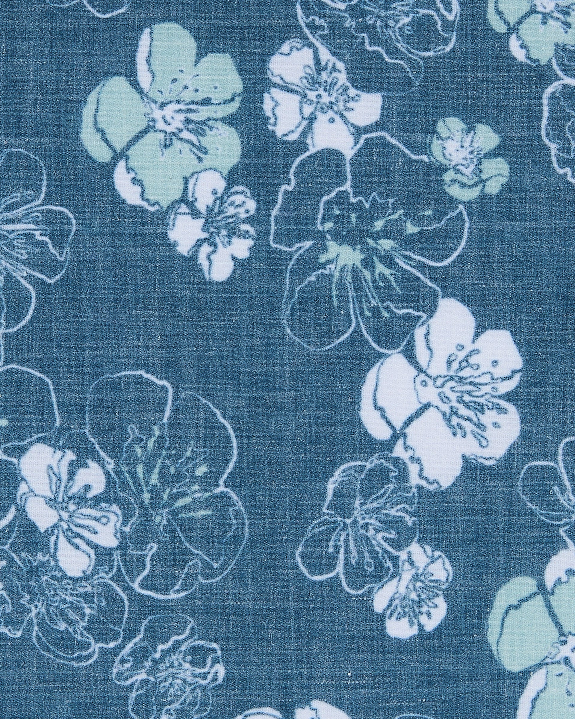 Close-up of the Celadine Woven Shirt’s blue fabric with white and light green floral print.