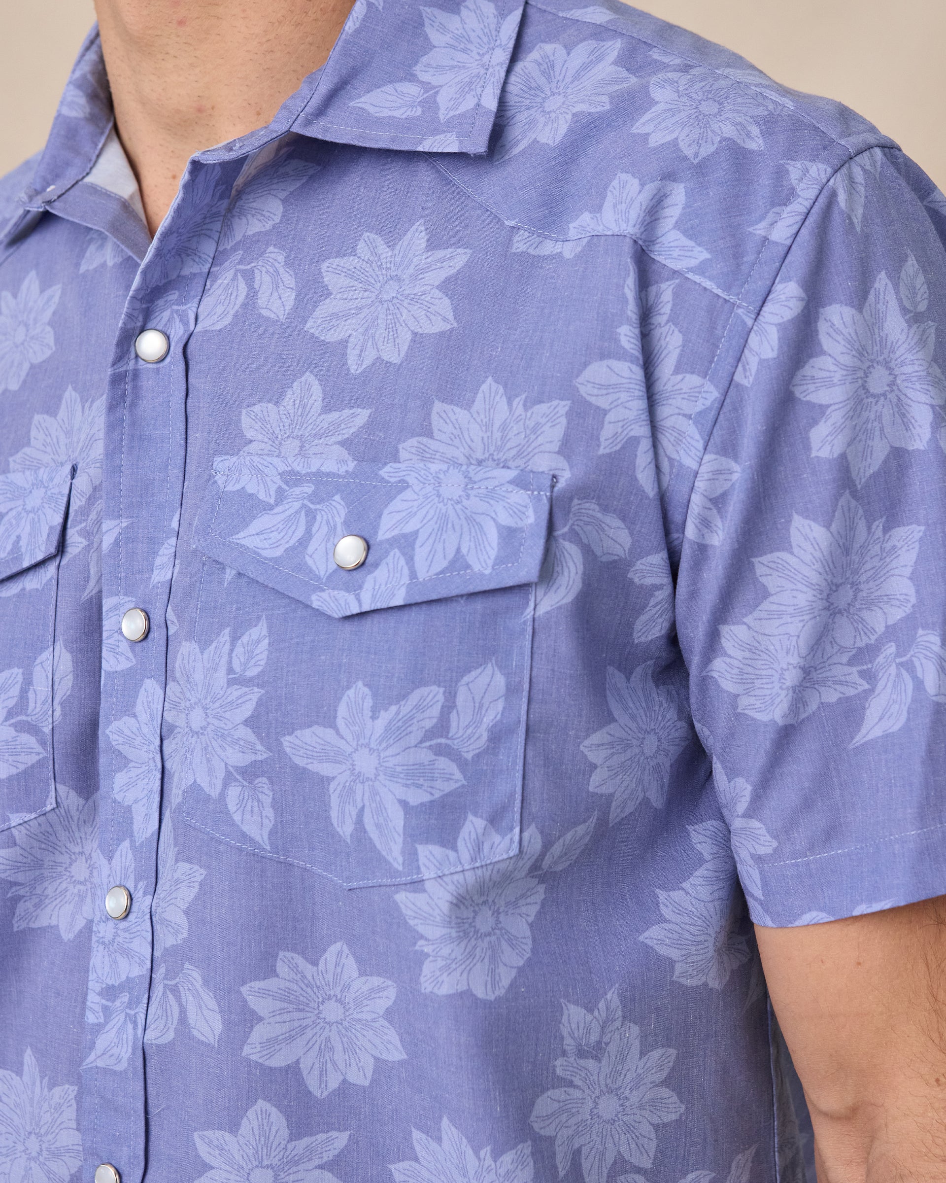 Chest detail of the Treviso Bay Woven Shirt in Tidal Blue highlighting dual flap chest pockets, pearl snap closures, and tonal floral pattern
