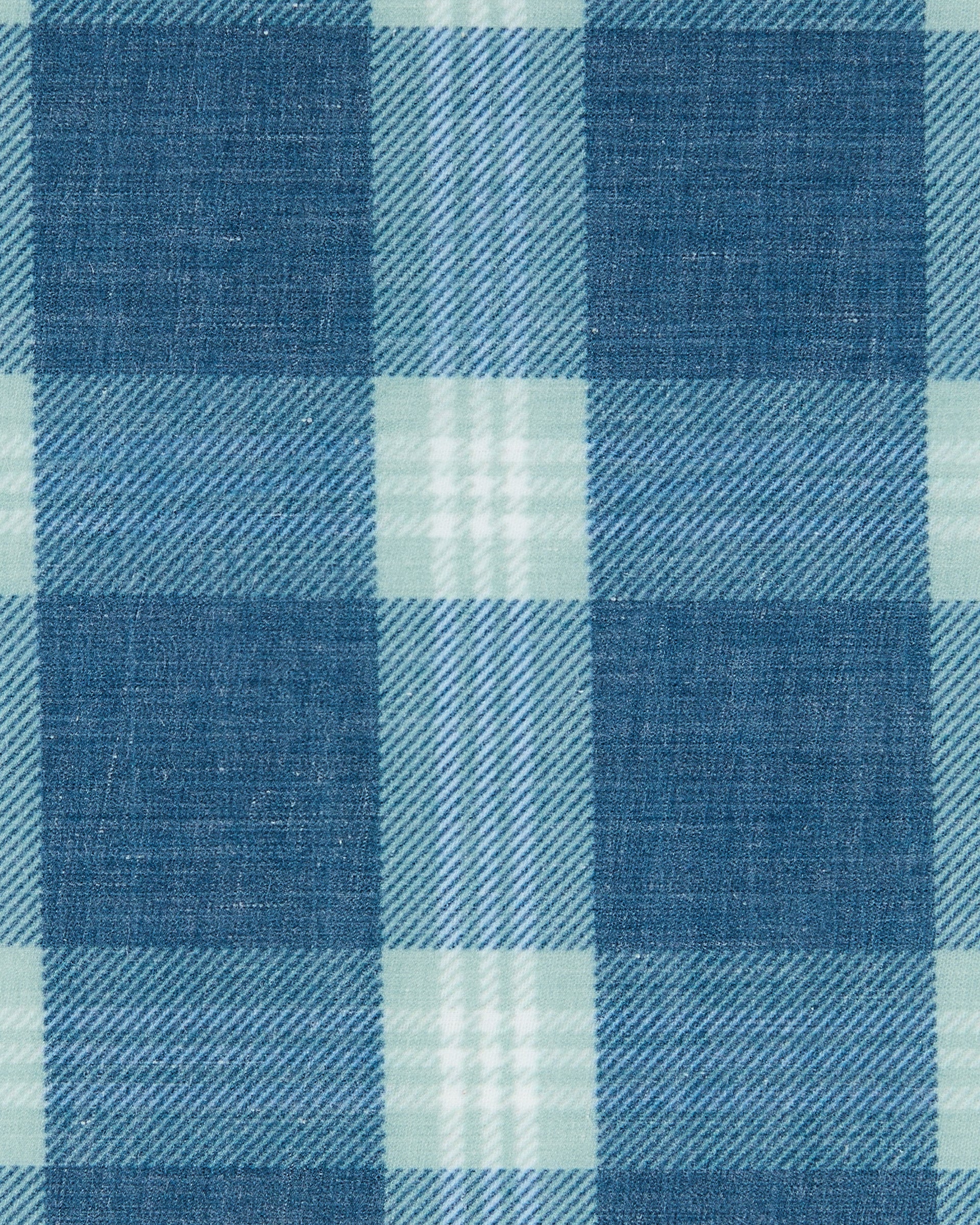 Close-up of the Jasper Woven Shirt fabric showing the blue and light green plaid pattern and woven texture.