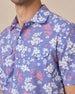 Close up of Paniolo Woven Shirt in Tidal Blue featuring a white and coral hibiscus floral print, pearl snap buttons, and dual chest pockets