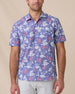 Model wearing the Paniolo Woven Shirt in Tidal Blue with a hibiscus floral print, pearl snap buttons, and dual chest pockets