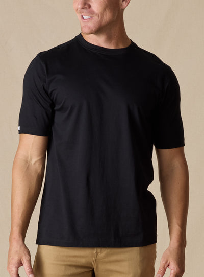 Men's Luxe Tee in Black, on model front view featuring a black short sleeve crew neck tee