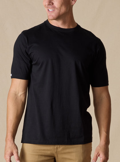Men's Luxe Tee in Black, on model front view featuring a black short sleeve crew neck tee