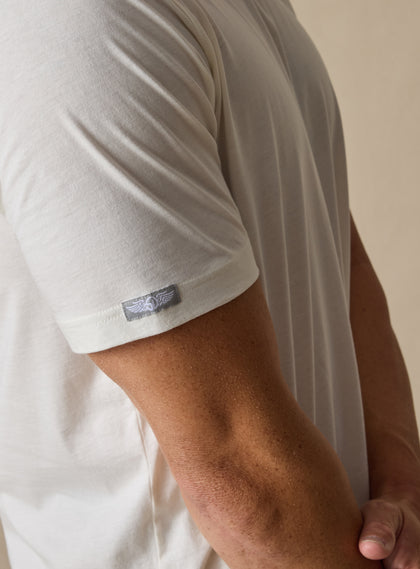 Men's Luxe Tee in Cream, on model close up sleeve view featuring a Straight Down woven label at the left sleeve