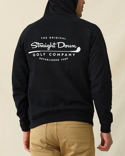 Men's Club Pro Hoodie in Black, back view on model featuring the large Straight Down Golf Company "Established 1989" graphic centered on the back, paired with tan pants