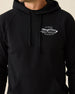 Men's Club Pro Hoodie in Black, close-up front view on model highlighting the Straight Down Golf Company "Established 1989" logo detail on the left chest