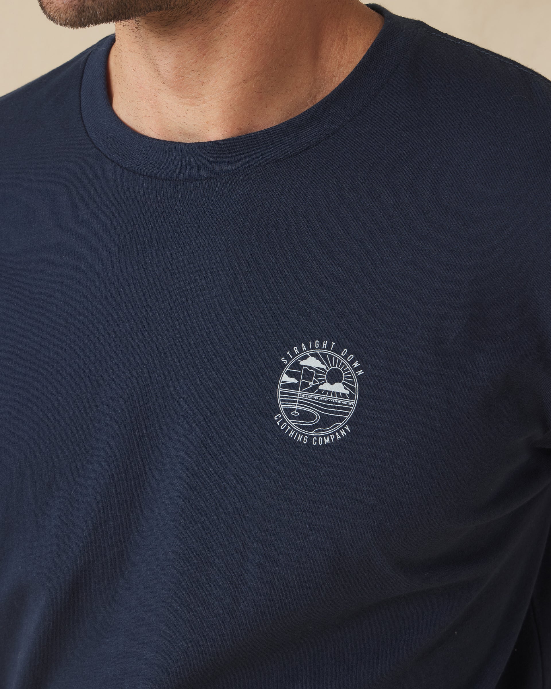 Close-up of navy t-shirt with Straight Down golf logo graphic on chest