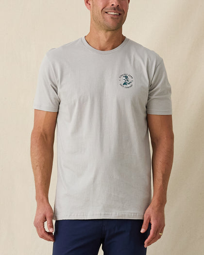 Men's Alligator Alley Tee in Light Grey, front model view featuring a light grey short sleeve crewneck tee with the Straight Down Golf Company Est. 1989 alligator graphic on the left chest paired with navy pants