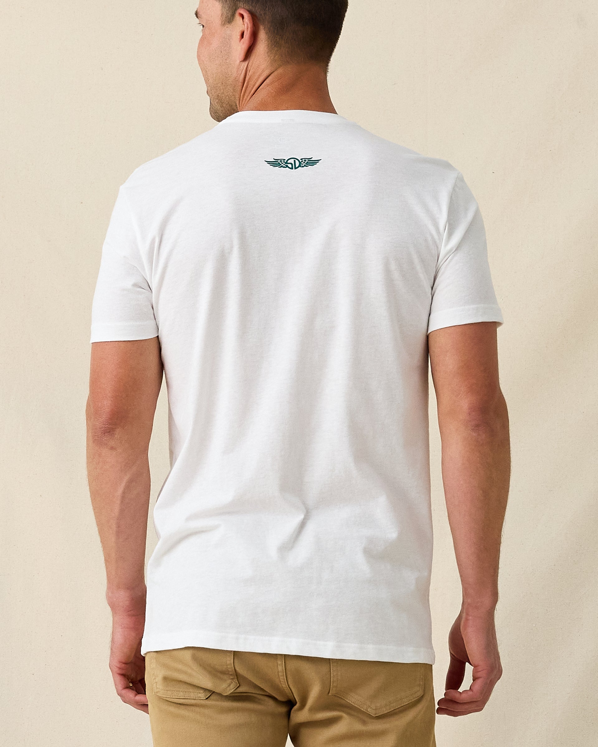 Men's Munch Tee in White, back view on model featuring a white base with a small Straight Down logo at upper back, paired with khaki pants