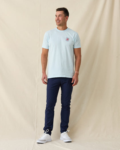 Men's Hibiscus 89 Tee in Light Blue, full length front view on model featuring the Straight Down Golf Company hibiscus logo on the left chest, paired with navy pants and white shoes
