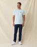 Men's Hibiscus 89 Tee in Light Blue, full length front view on model featuring the Straight Down Golf Company hibiscus logo on the left chest, paired with navy pants and white shoes