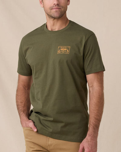 Man wearing the American Standard Tee in Army Green with a small gold graphic on the left chest.