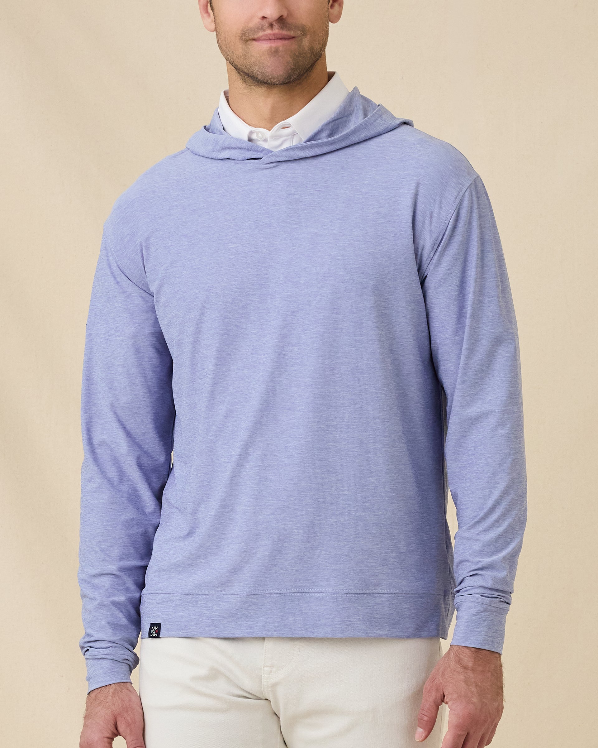 Model wearing the Hermosa Hoodie in Tidal Blue layered over a white polo