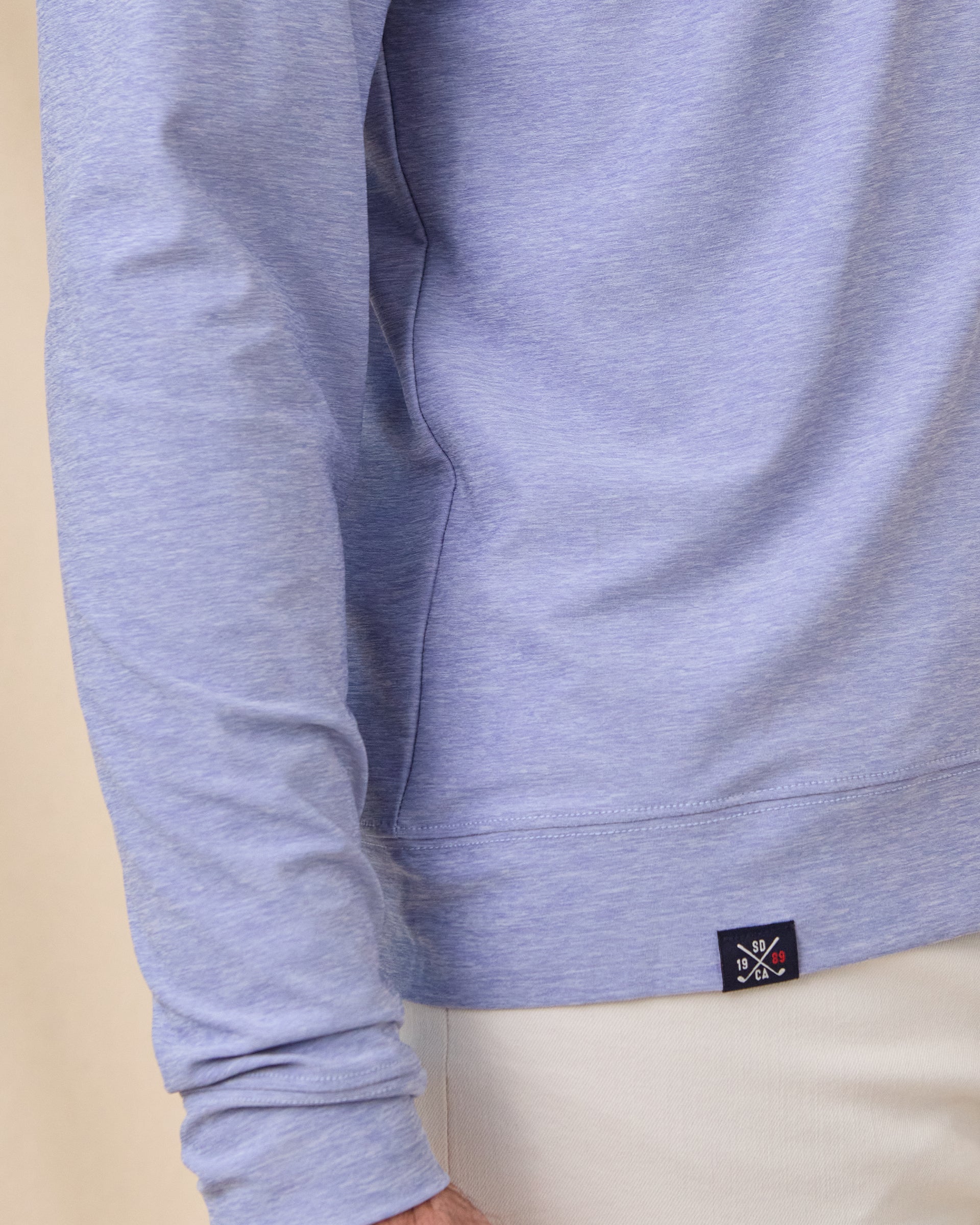 Close-up of the Hermosa Hoodie in Tidal Blue highlighting the cross-dyed heather fabric and signature Straight Down hem label