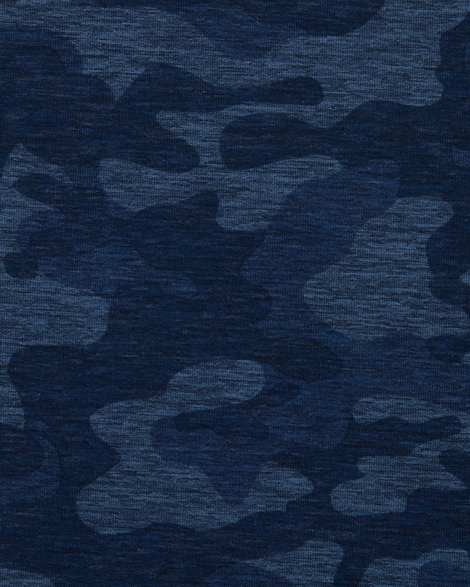 A close-up of a textured fabric with a dark blue camouflage pattern in multiple shades of navy and blue.