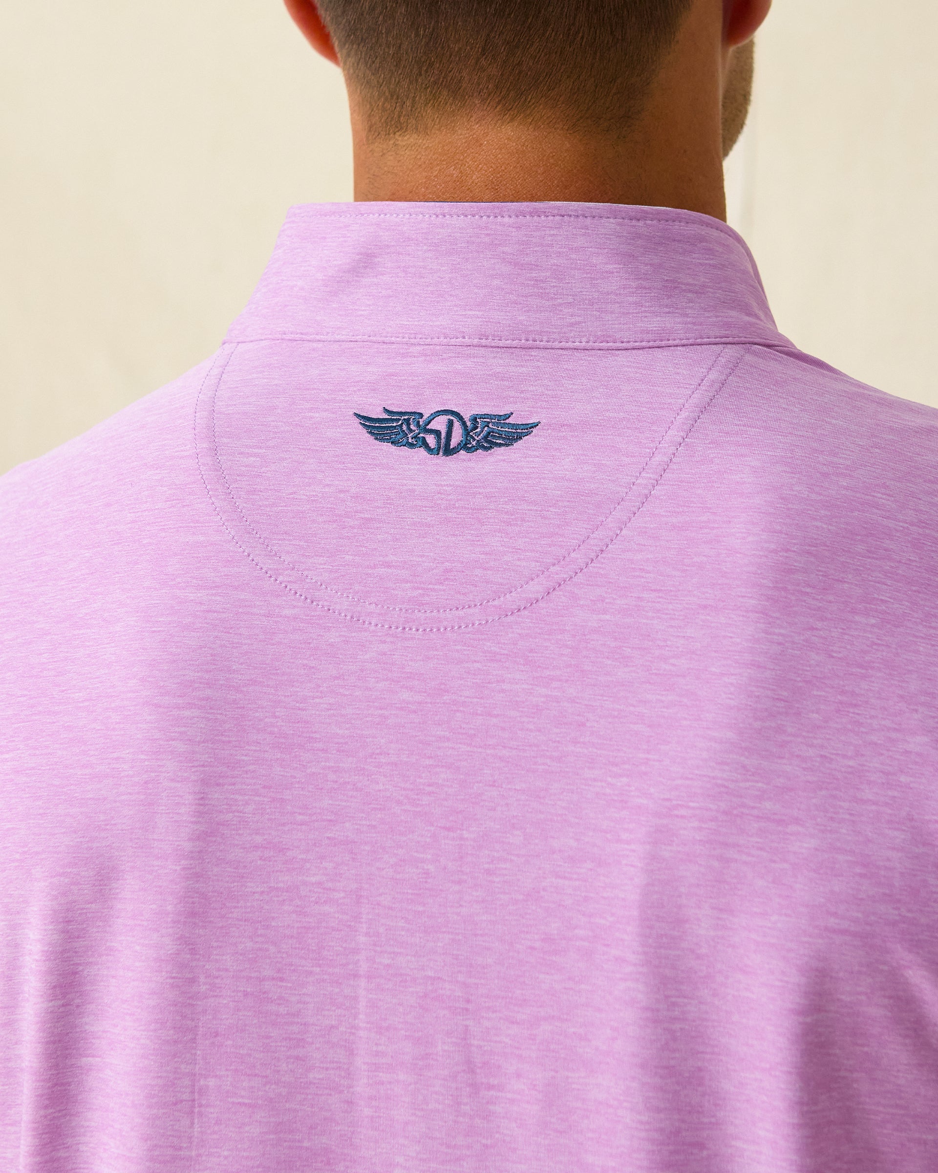 Close-up of back neck showing embroidered Straight Down winged logo on pink pullover.