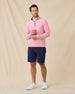 Model wearing the Oceanside 2.0 Quarter Zip in Punch Pink with navy golf shorts