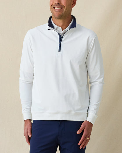Men’s white long sleeve quarter-zip pullover with contrast navy inner collar, worn with navy pants.