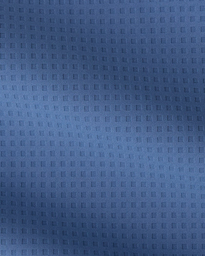 A close-up of a textured blue fabric with a repeating embossed square grid pattern.