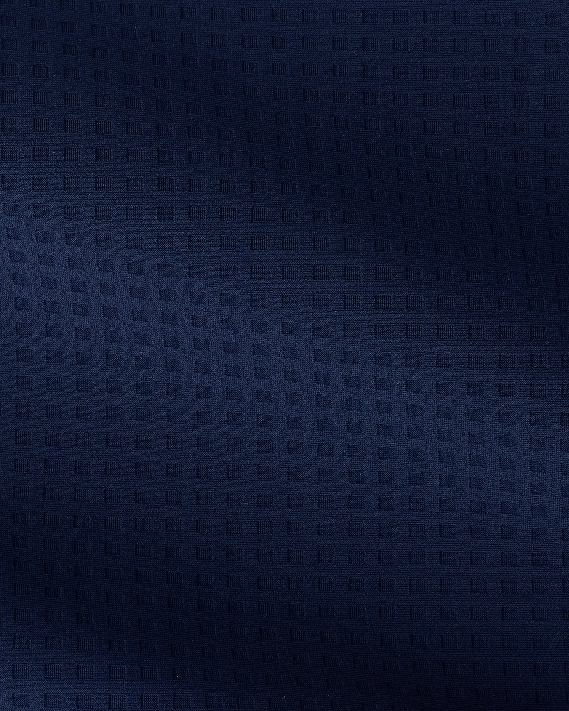 A close-up of dark navy blue textured fabric with a subtle woven geometric pattern.