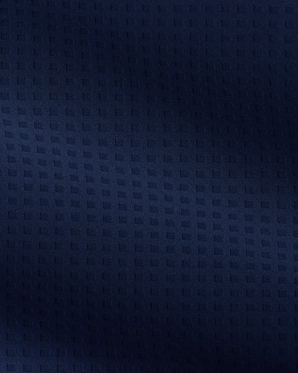 A close-up of dark navy blue textured fabric with a subtle woven geometric pattern.