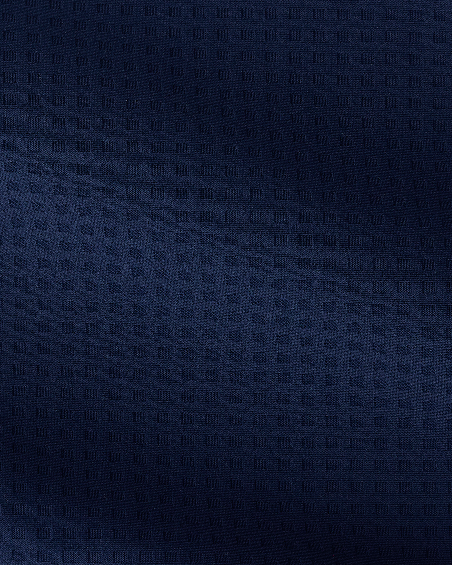 A close-up of a dark navy blue textured fabric with a subtle woven geometric pattern.